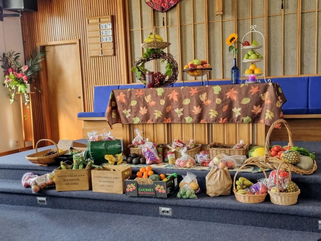 Display of harvest festival gifts in the church - fruit and veges over and around the communion table.