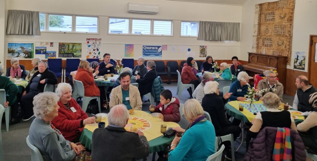 A diverse range of people talking at tables.