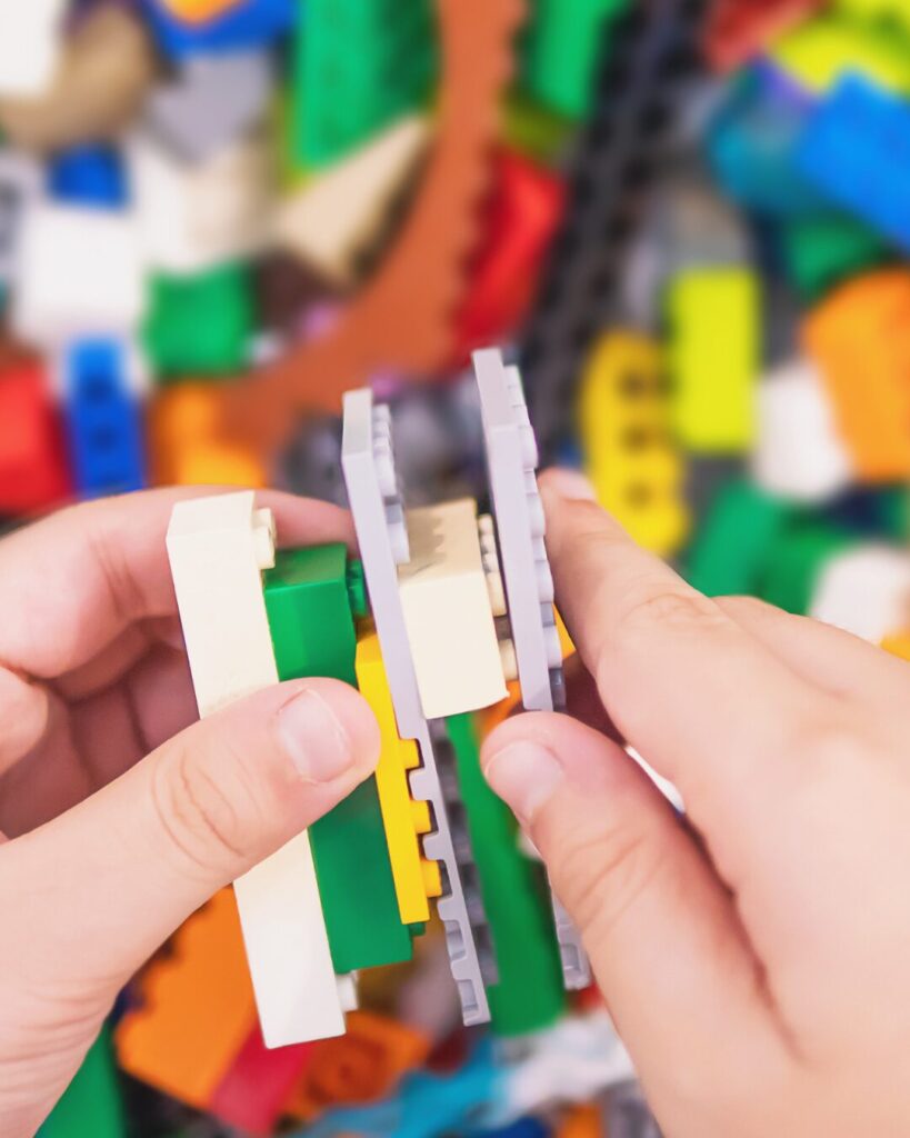 child's hands holding lego